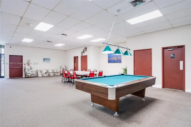 a room with pool table and windows