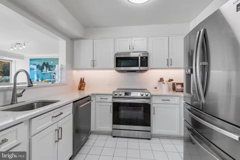 a dining room with furniture a chandelier and wooden floor