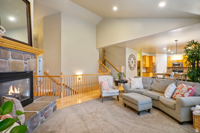 557 South 1470th Street East Springville, UT 84663 - Photo 9 of 46 Living area featuring a stone fireplace, lofted ceiling, recessed lighting, and light wood finished floors