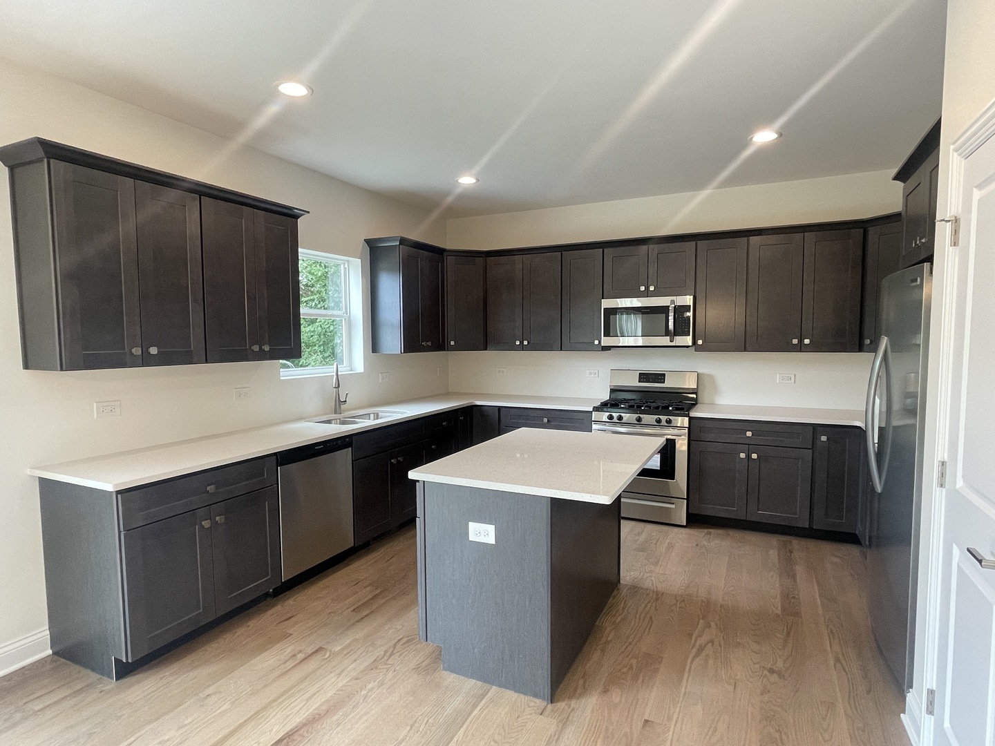 18800 Sara Road Mokena, IL 60448 - Photo 8 of 24 a kitchen with stainless steel appliances kitchen island granite countertop a stove a sink dishwasher and a refrigerator with wooden floor