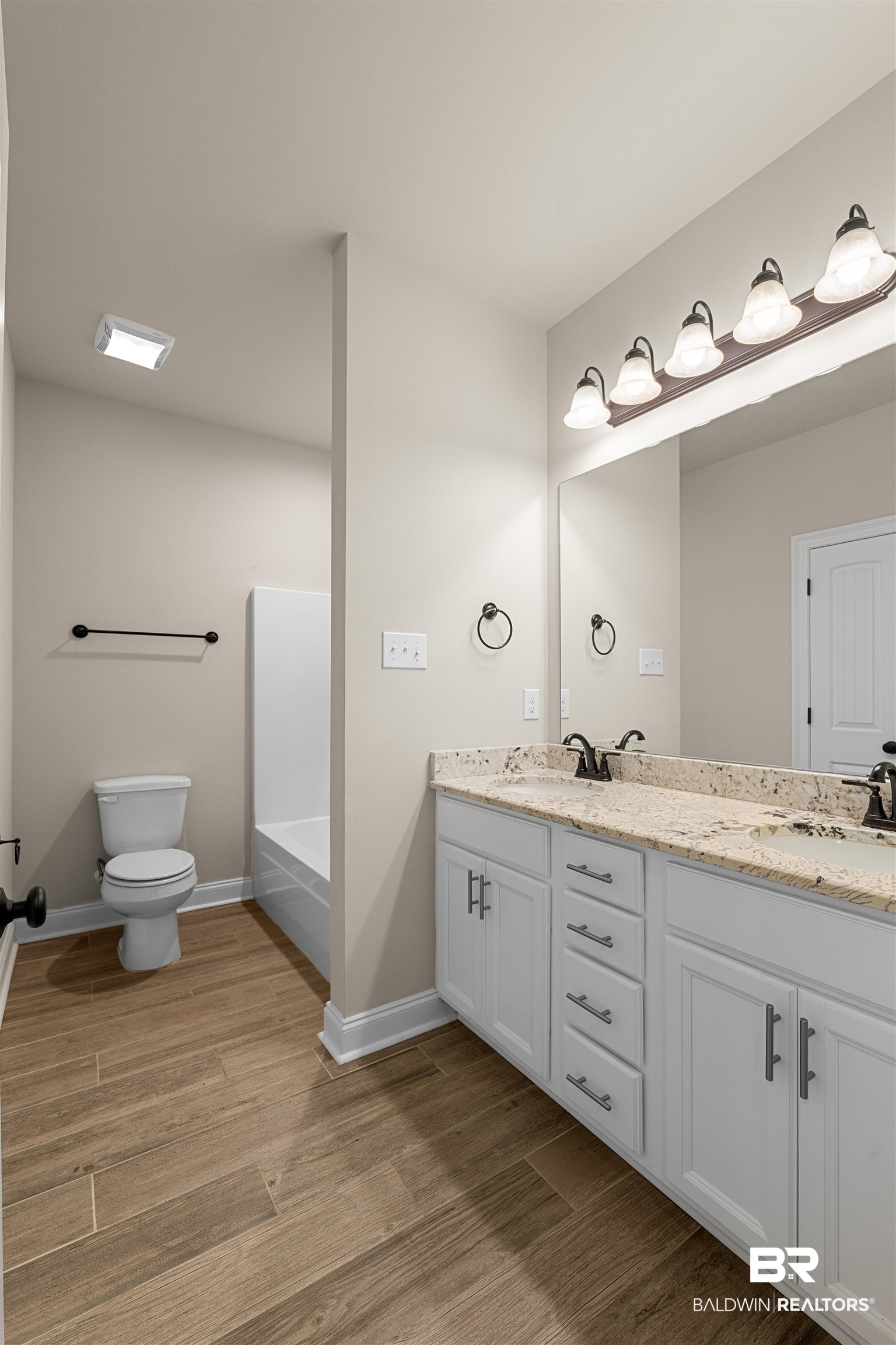 991 Dalton Circle Foley, AL 36535 - Photo 27 of 35 Bathroom featuring double vanity, wood finished floors, and a bath