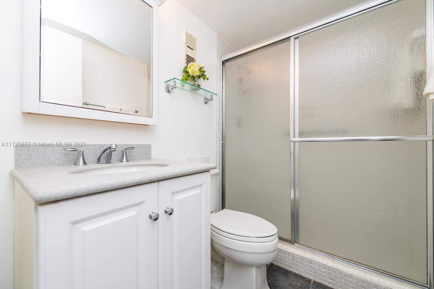 9273 Collins Avenue, Unit 801 Surfside, FL 33154 - Photo 4 of 47 a bathroom with a granite countertop sink vanity and toilet