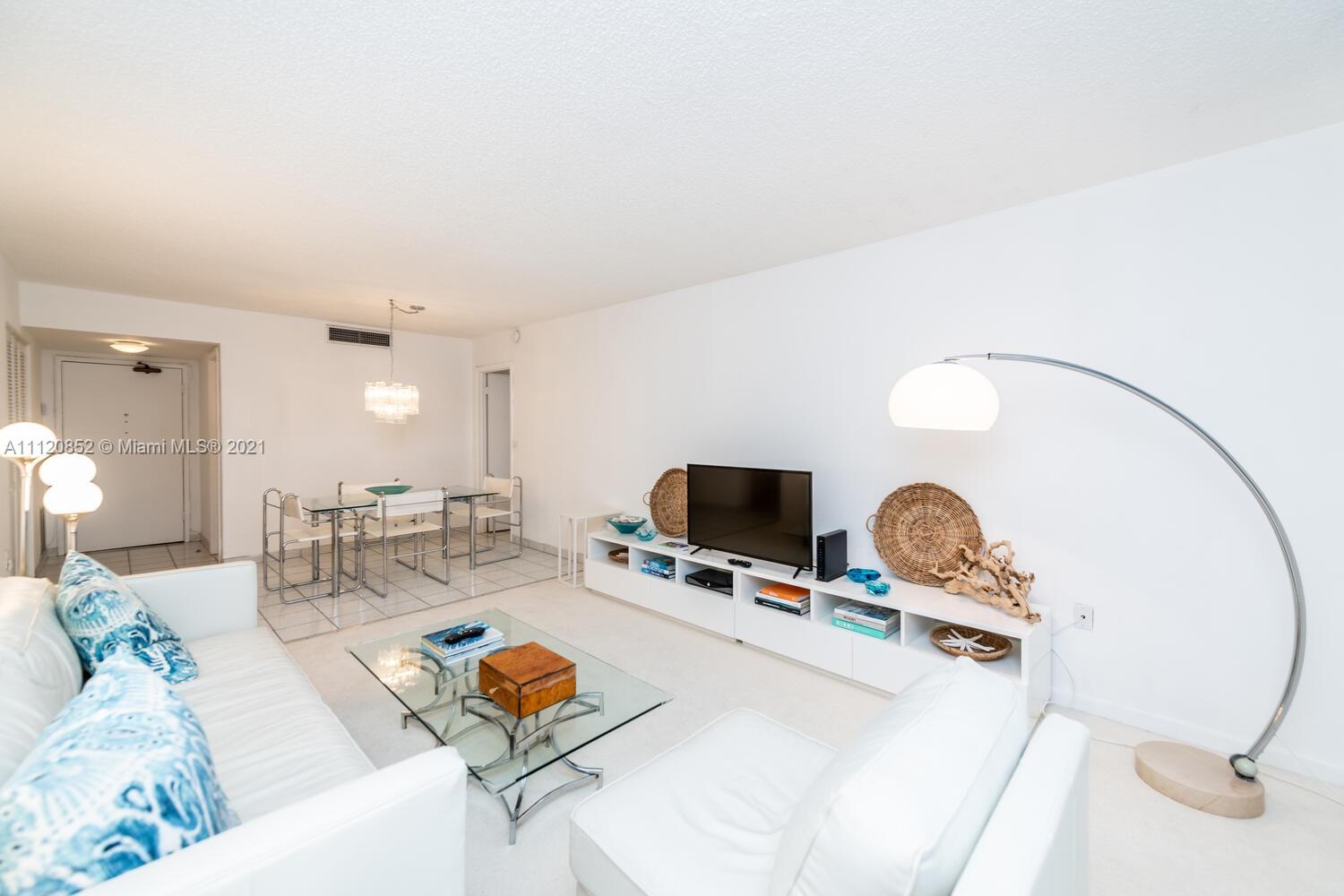 9273 Collins Avenue, Unit 801 Surfside, FL 33154 - Photo 6 of 47 a living room with furniture and a flat screen tv