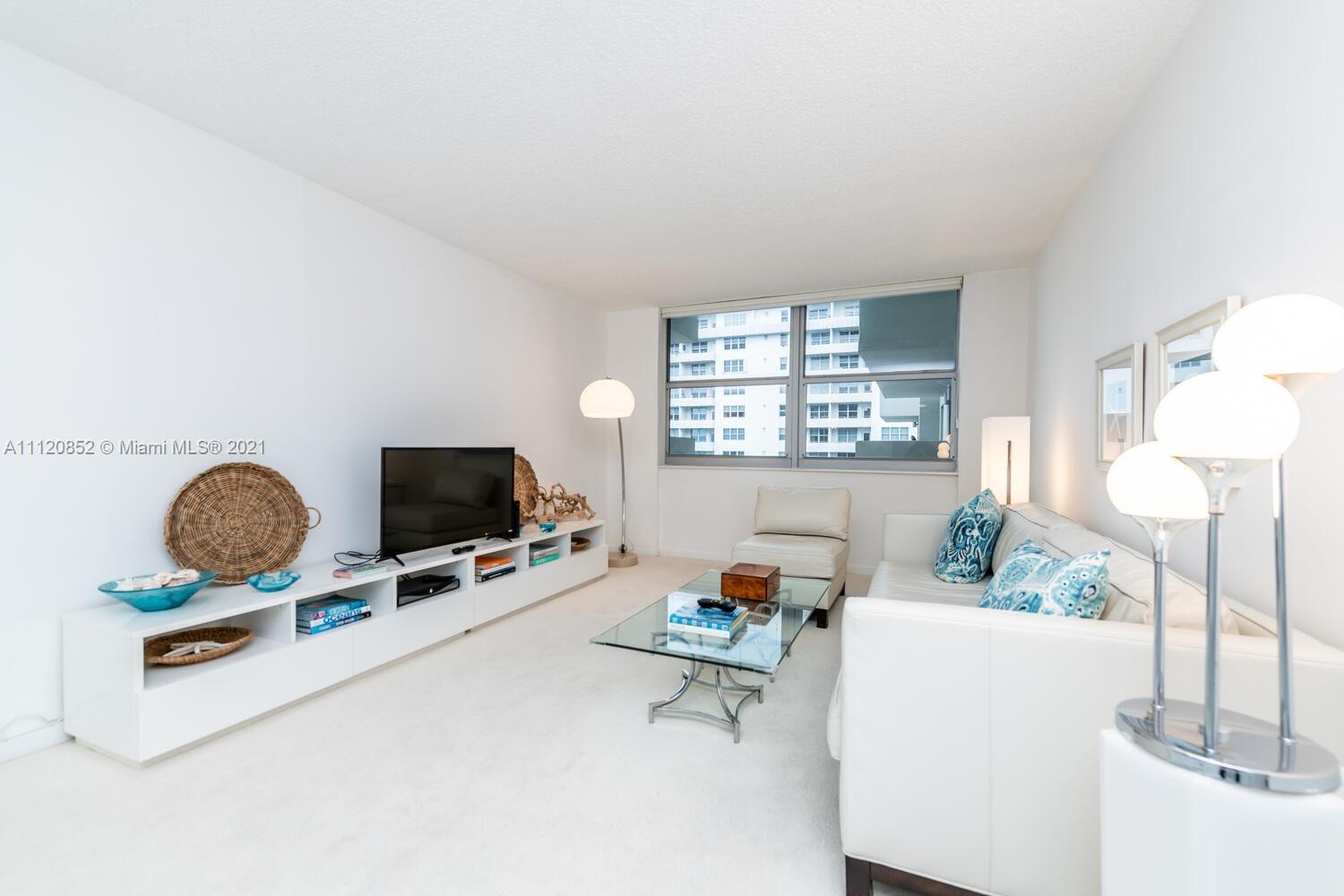 9273 Collins Avenue, Unit 801 Surfside, FL 33154 - Photo 7 of 47 a living room with furniture and a flat screen tv
