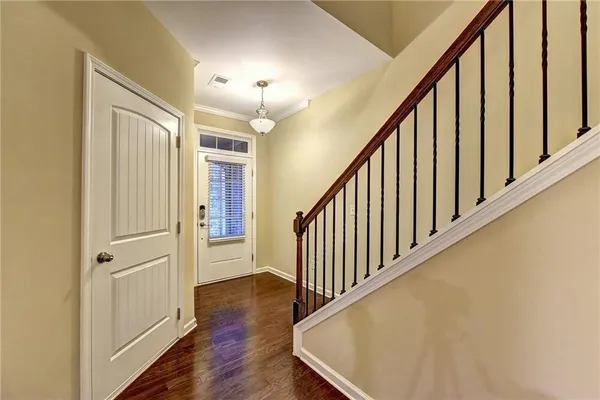 a view of a hallway with wooden floor and staircase