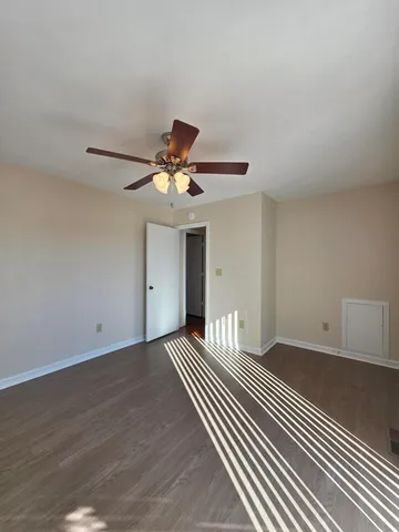 a view of an empty room with wooden floor