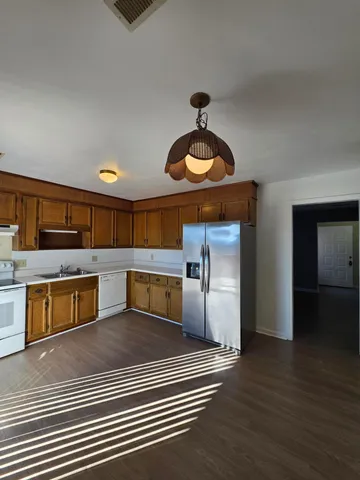 a kitchen with stainless steel appliances kitchen island a stove a sink and a refrigerator
