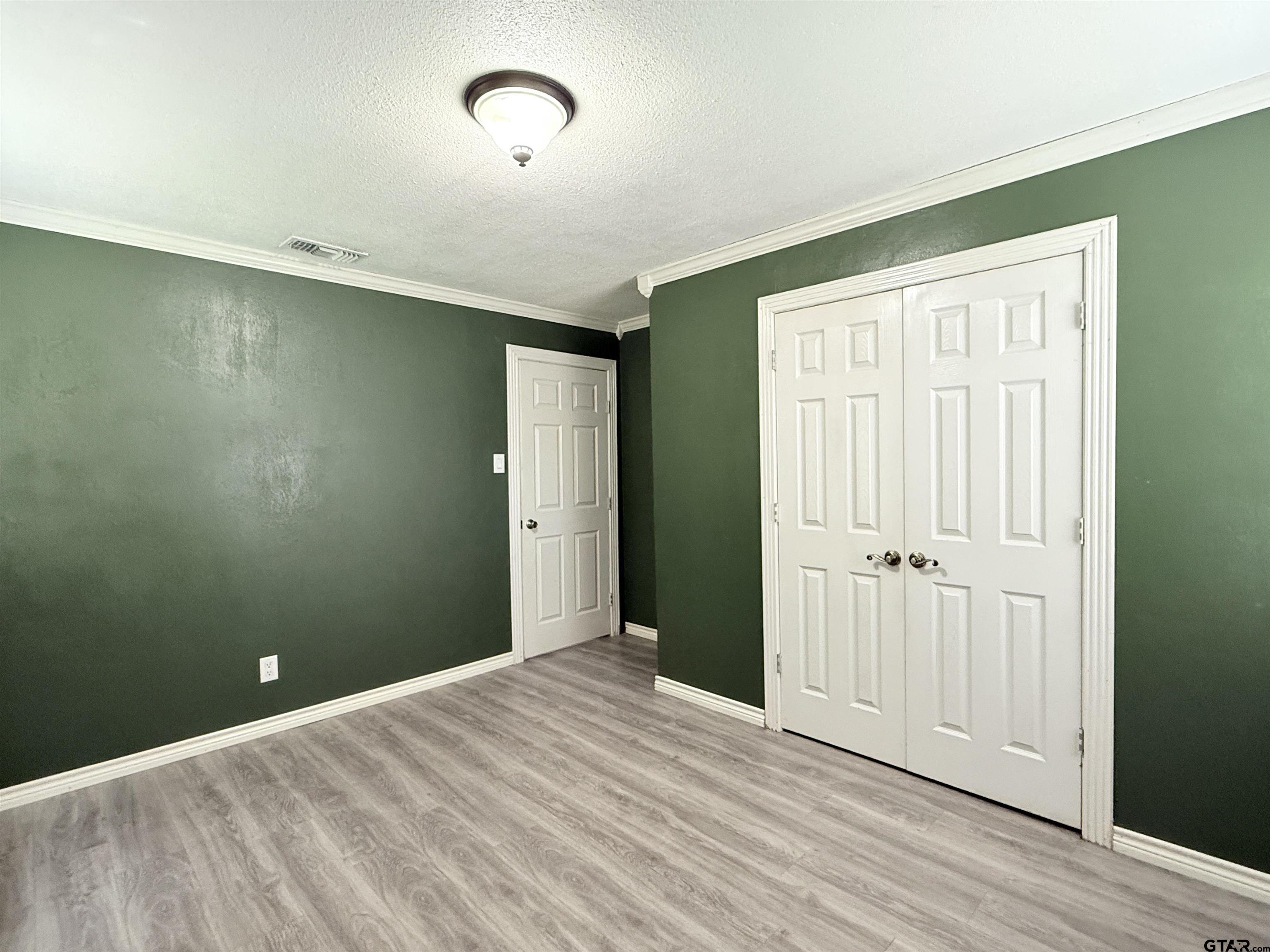 404 Beckley Street Kilgore, TX 75662 - Photo 11 of 20 an empty room with wooden floor and windows