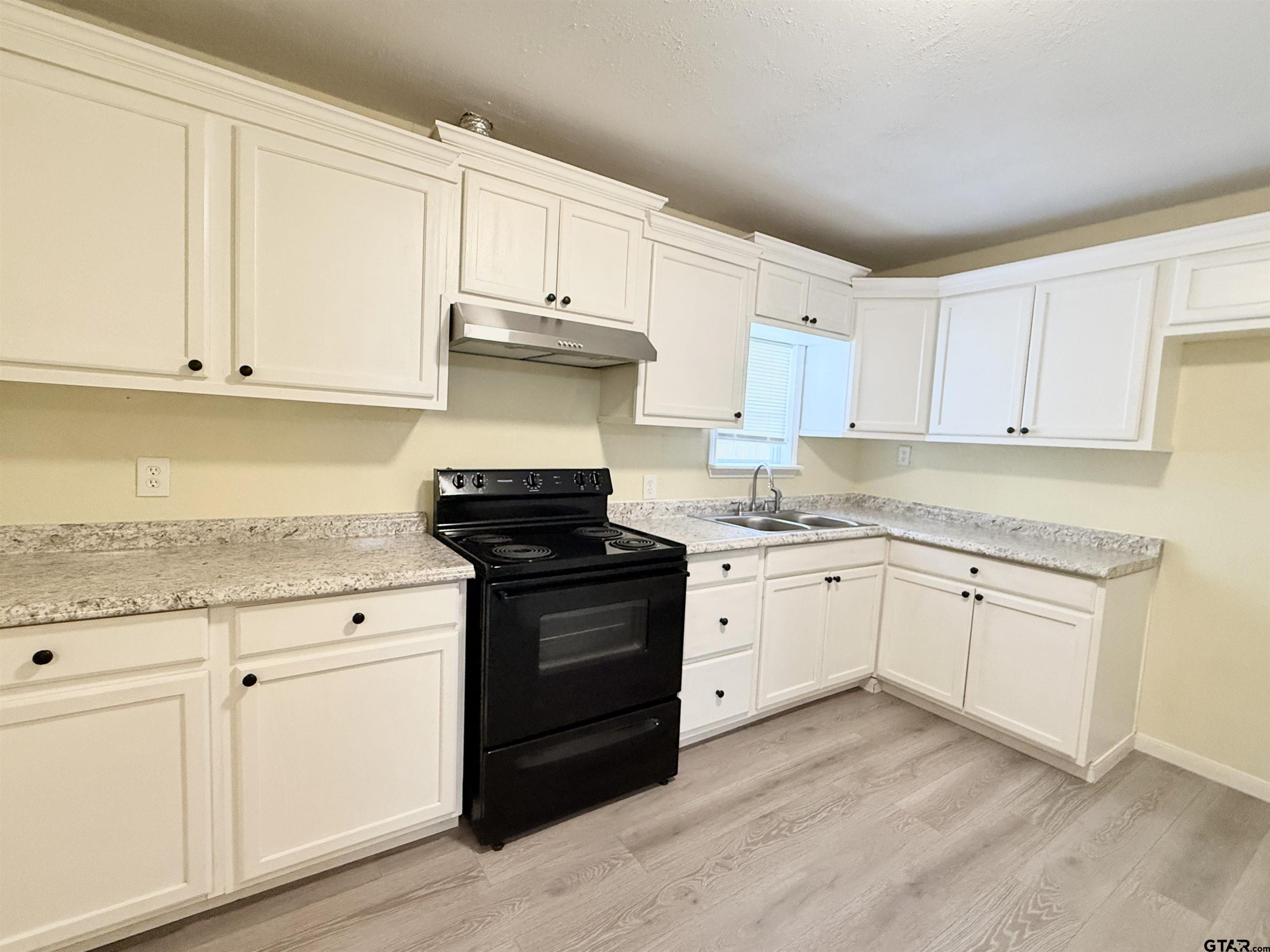 404 Beckley Street Kilgore, TX 75662 - Photo 5 of 20 a kitchen with granite countertop white cabinets and appliances
