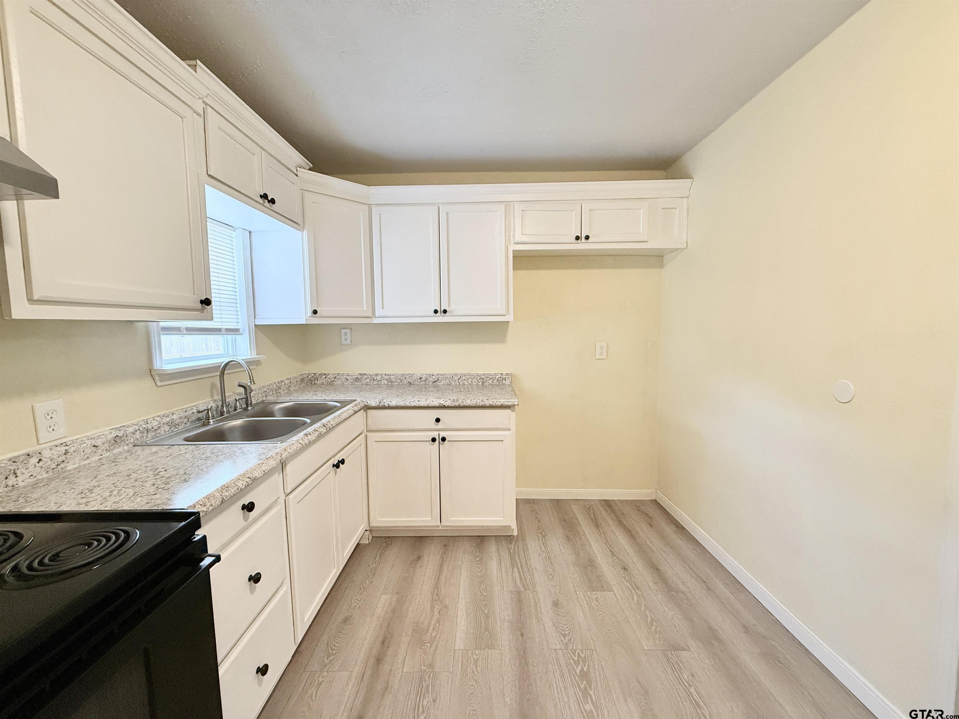 404 Beckley Street Kilgore, TX 75662 - Photo 6 of 20 a kitchen with a sink a stove and cabinets