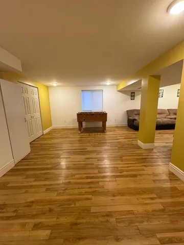 a view of a dining room with furniture a kitchen wooden floor and chandelier