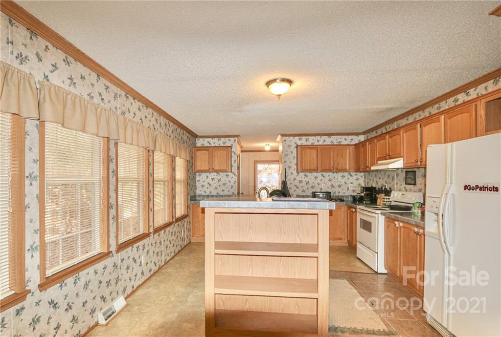 117 Valley Springs Road Olin, NC 28660 - Photo 14 of 38 a kitchen with stainless steel appliances granite countertop a refrigerator and a stove top oven