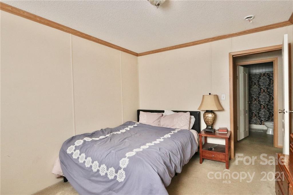 117 Valley Springs Road Olin, NC 28660 - Photo 18 of 38 a bedroom with a bed and a table