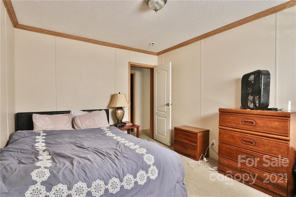 117 Valley Springs Road Olin, NC 28660 - Photo 19 of 38 a bedroom with a bed and a dresser