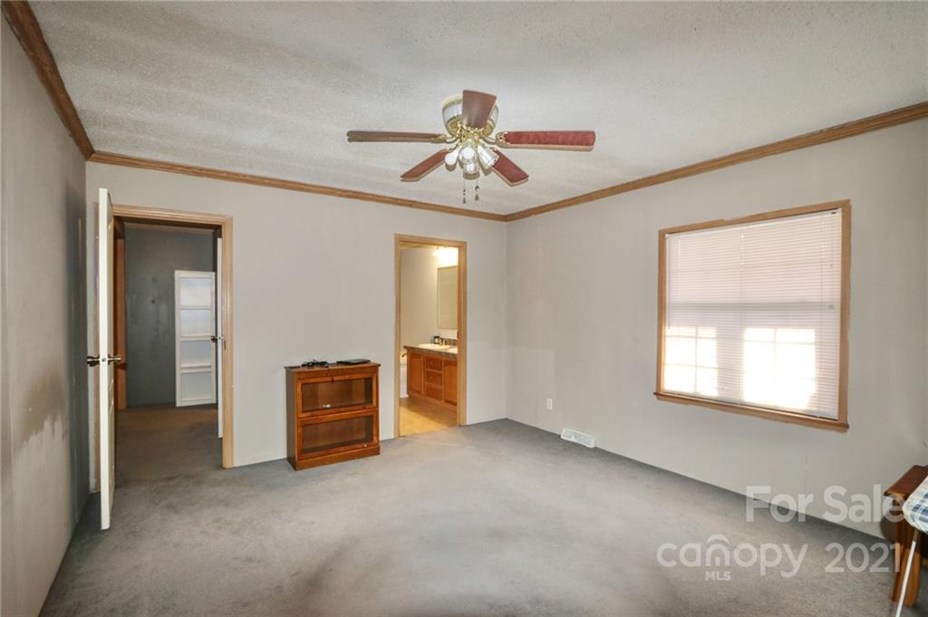 117 Valley Springs Road Olin, NC 28660 - Photo 20 of 38 a view of a livingroom with a chandelier fan and windows