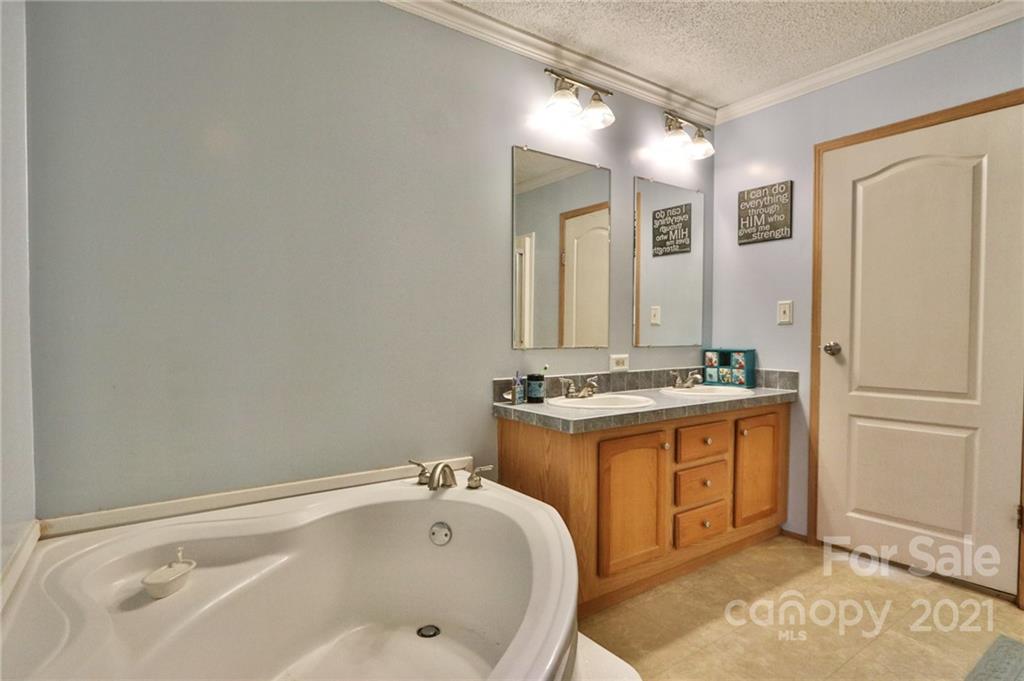 117 Valley Springs Road Olin, NC 28660 - Photo 24 of 38 a bathroom with a tub sink and mirror
