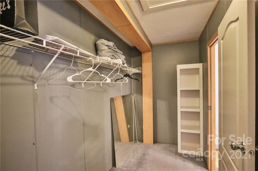 117 Valley Springs Road Olin, NC 28660 - Photo 25 of 38 a view of walk in closet with empty racks