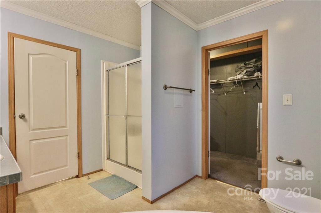 117 Valley Springs Road Olin, NC 28660 - Photo 28 of 38 a view of a bathroom with a glass door shower and a sink