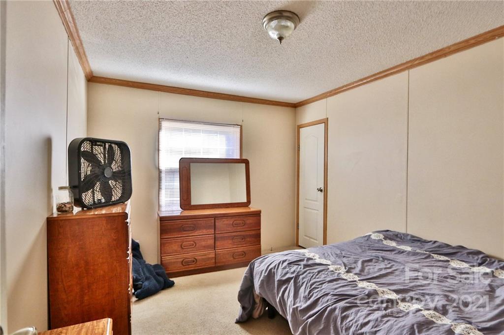 117 Valley Springs Road Olin, NC 28660 - Photo 31 of 38 a bedroom with a bed and wooden floor