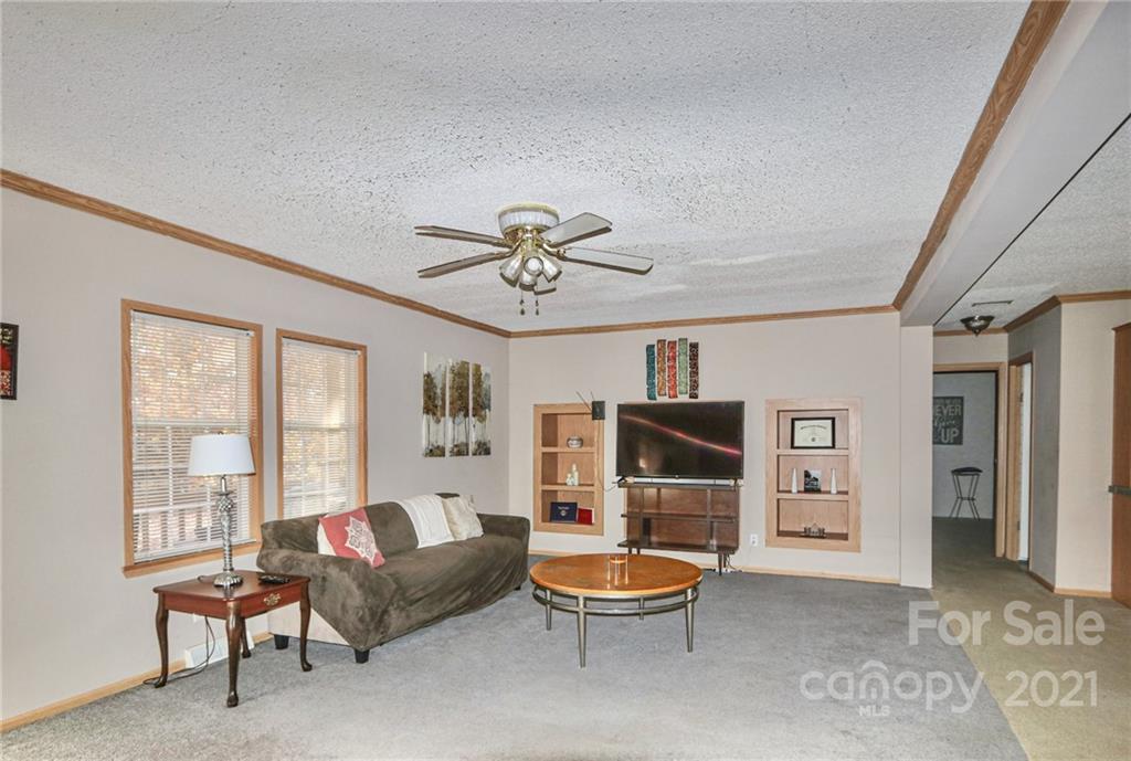 117 Valley Springs Road Olin, NC 28660 - Photo 5 of 38 a living room with furniture a flat screen tv and a large window