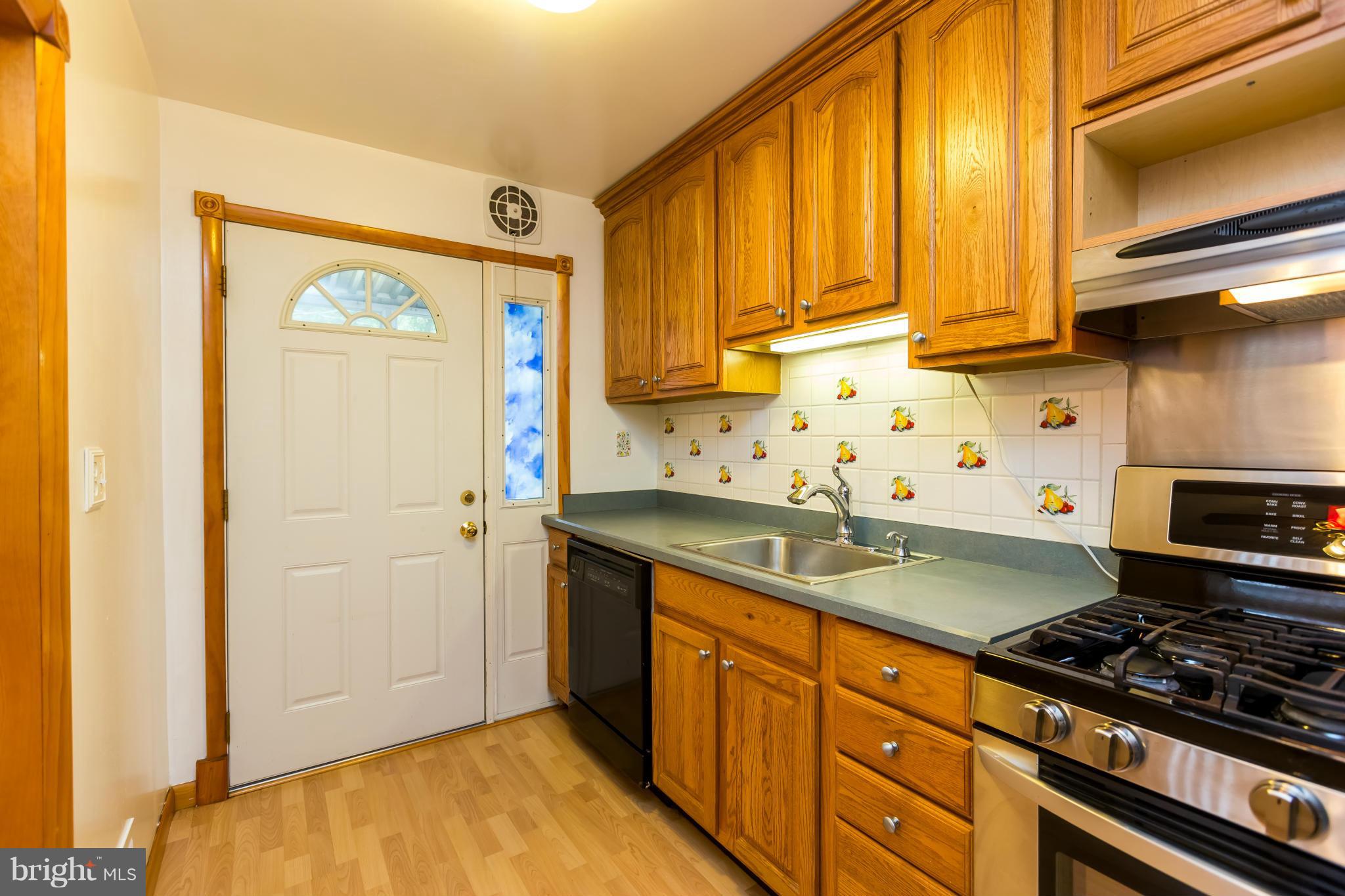 4424 Scotia Road Baltimore, MD 21227 - Photo 11 of 26 a kitchen with stainless steel appliances granite countertop a sink stove and refrigerator