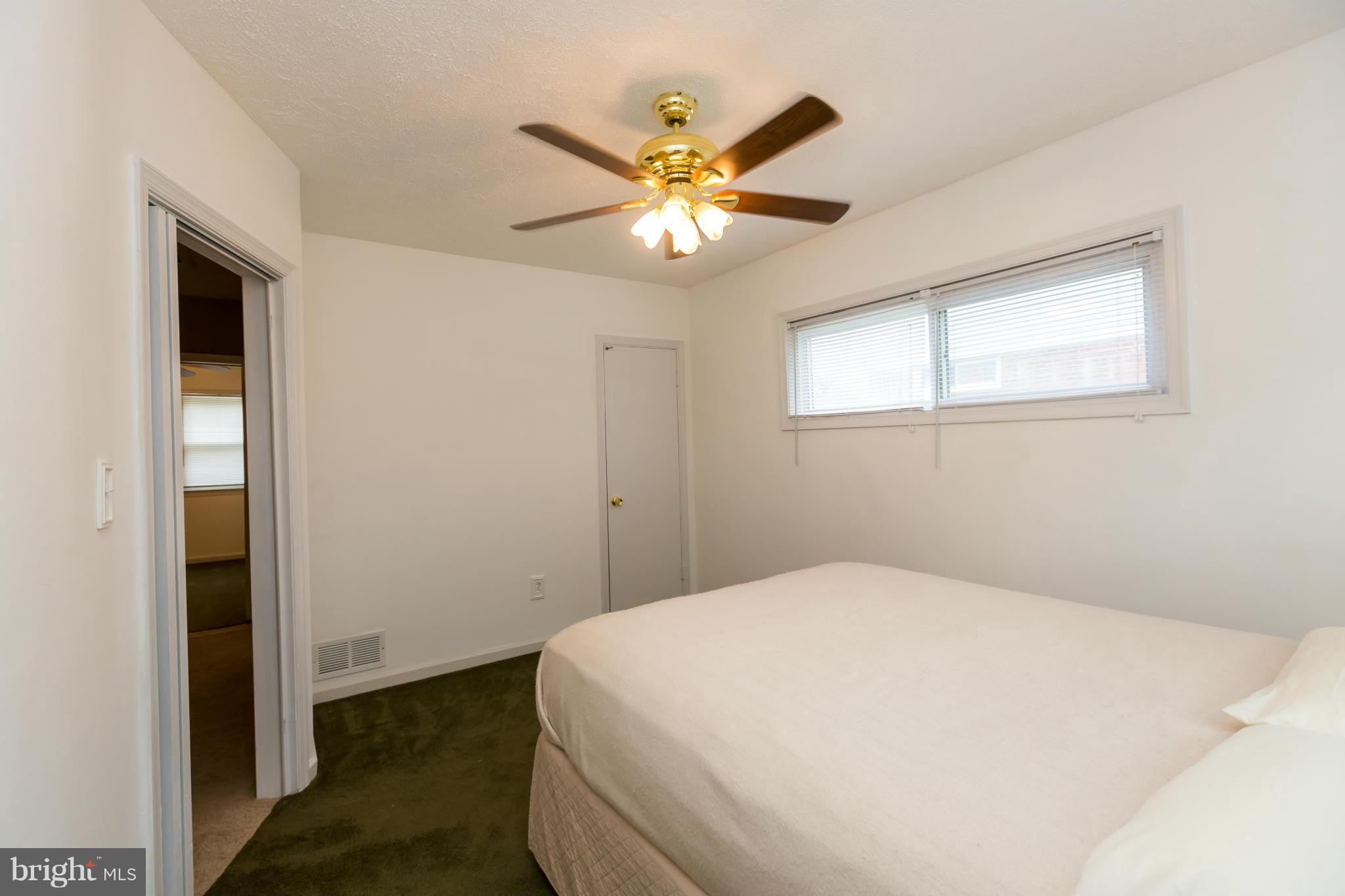 4424 Scotia Road Baltimore, MD 21227 - Photo 15 of 26 a bedroom with a bed and a chandelier