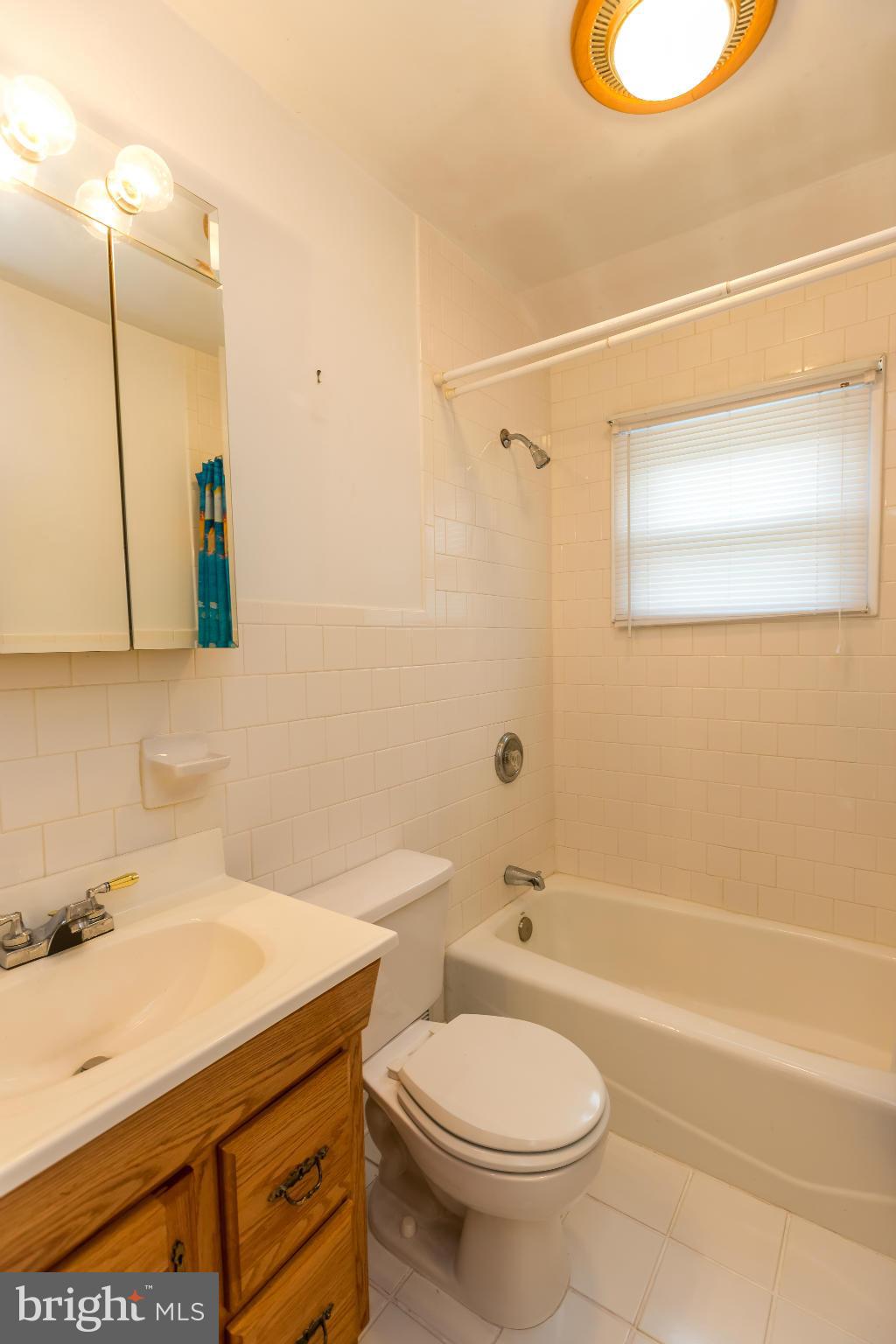 4424 Scotia Road Baltimore, MD 21227 - Photo 16 of 26 a bathroom with a sink a toilet and shower