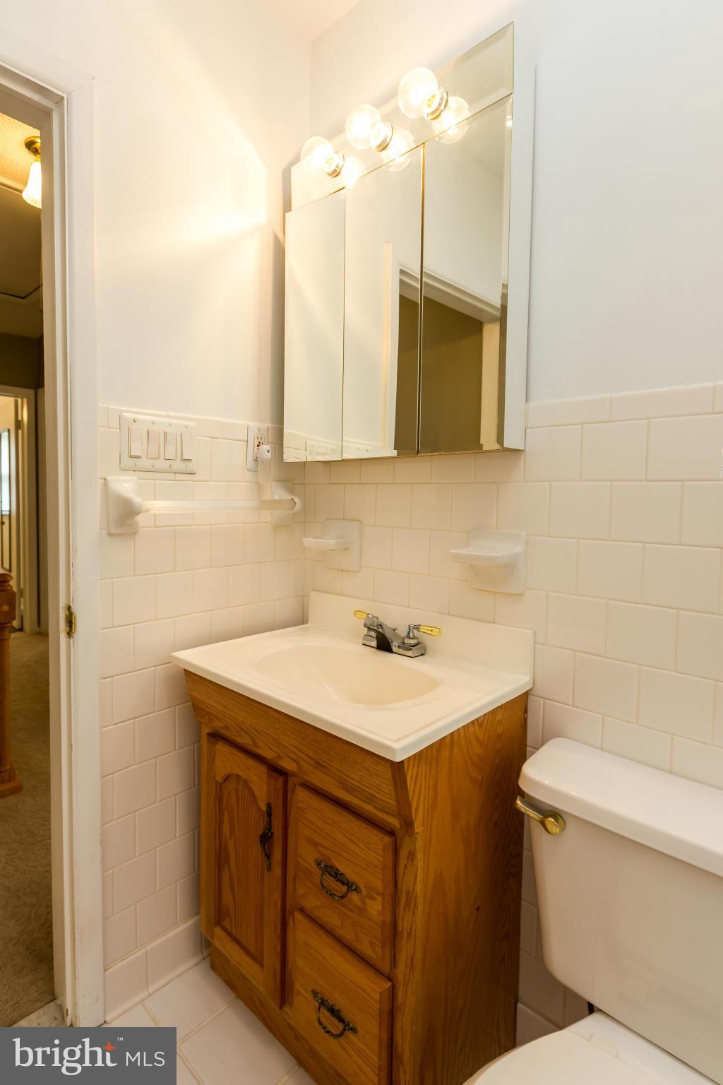 4424 Scotia Road Baltimore, MD 21227 - Photo 17 of 26 a bathroom with a sink a toilet and a mirror