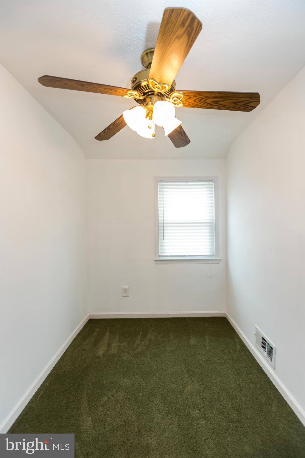 4424 Scotia Road Baltimore, MD 21227 - Photo 19 of 26 an empty room with a window and a chandelier fan