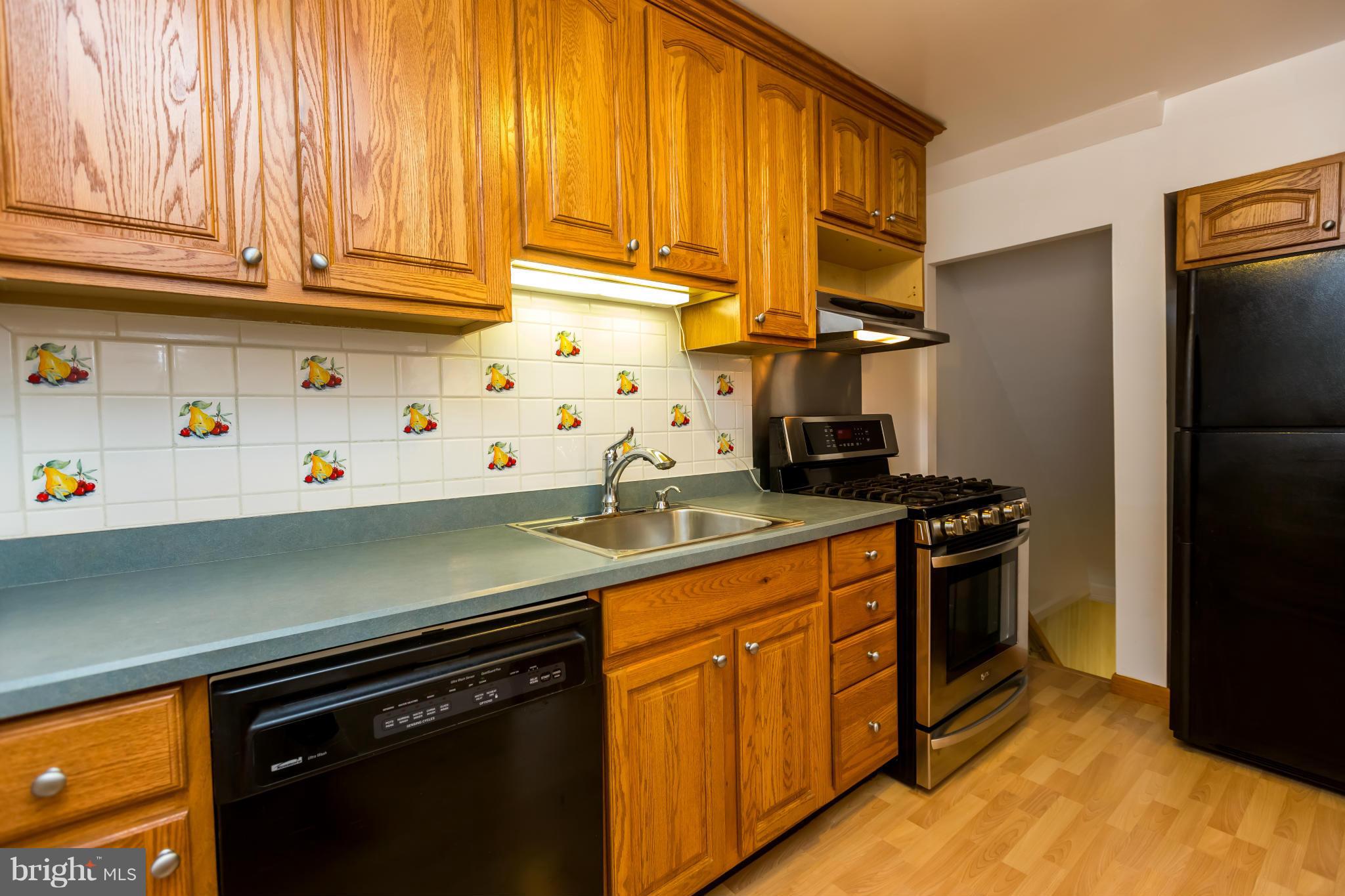 4424 Scotia Road Baltimore, MD 21227 - Photo 10 of 26 a kitchen with stainless steel appliances granite countertop a sink stove and refrigerator