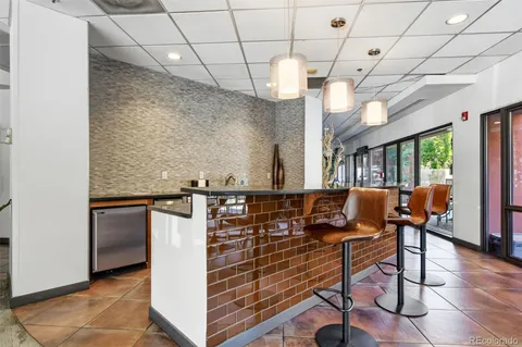a kitchen with stainless steel appliances granite countertop a stove and a view of living room