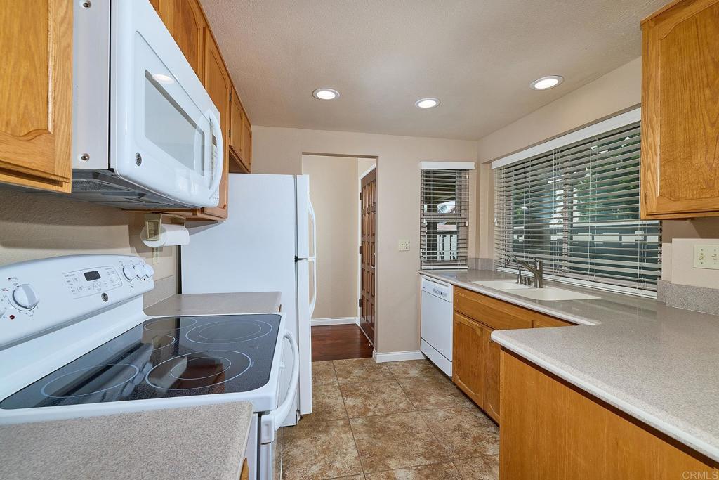 932 Alyssum Road Carlsbad, CA 92011 - Photo 11 of 31 a kitchen with stainless steel appliances granite countertop a sink a refrigerator and a stove