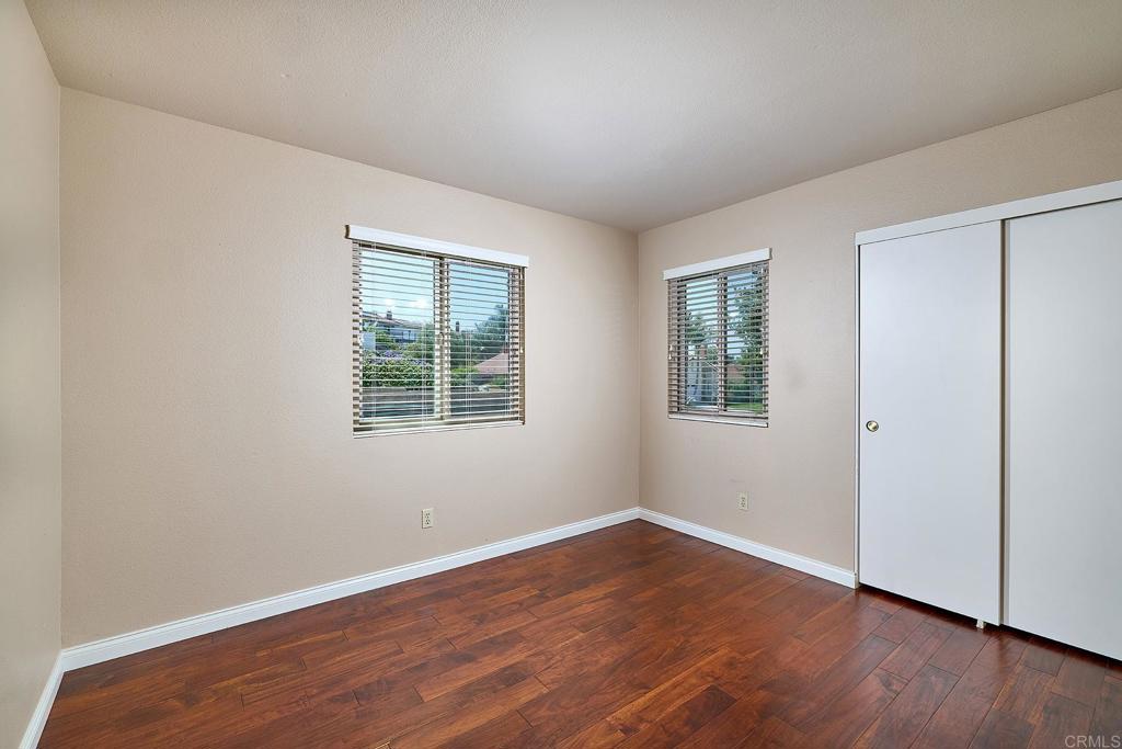 932 Alyssum Road Carlsbad, CA 92011 - Photo 15 of 31 an empty room with wooden floor and windows
