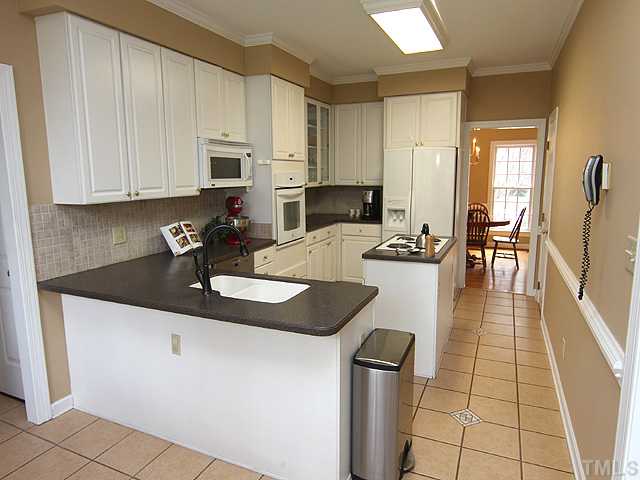 2402 Eddystone Road Raleigh, NC 27612 - Photo 8 of 25 a kitchen with granite countertop a sink a stove and cabinets