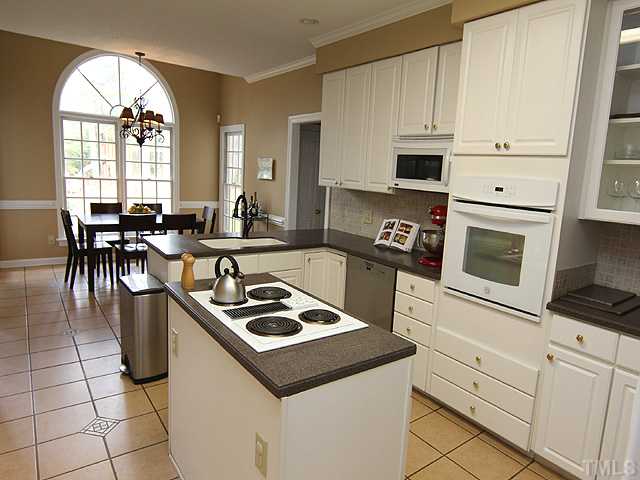 2402 Eddystone Road Raleigh, NC 27612 - Photo 9 of 25 a kitchen with cabinets and a stove top oven