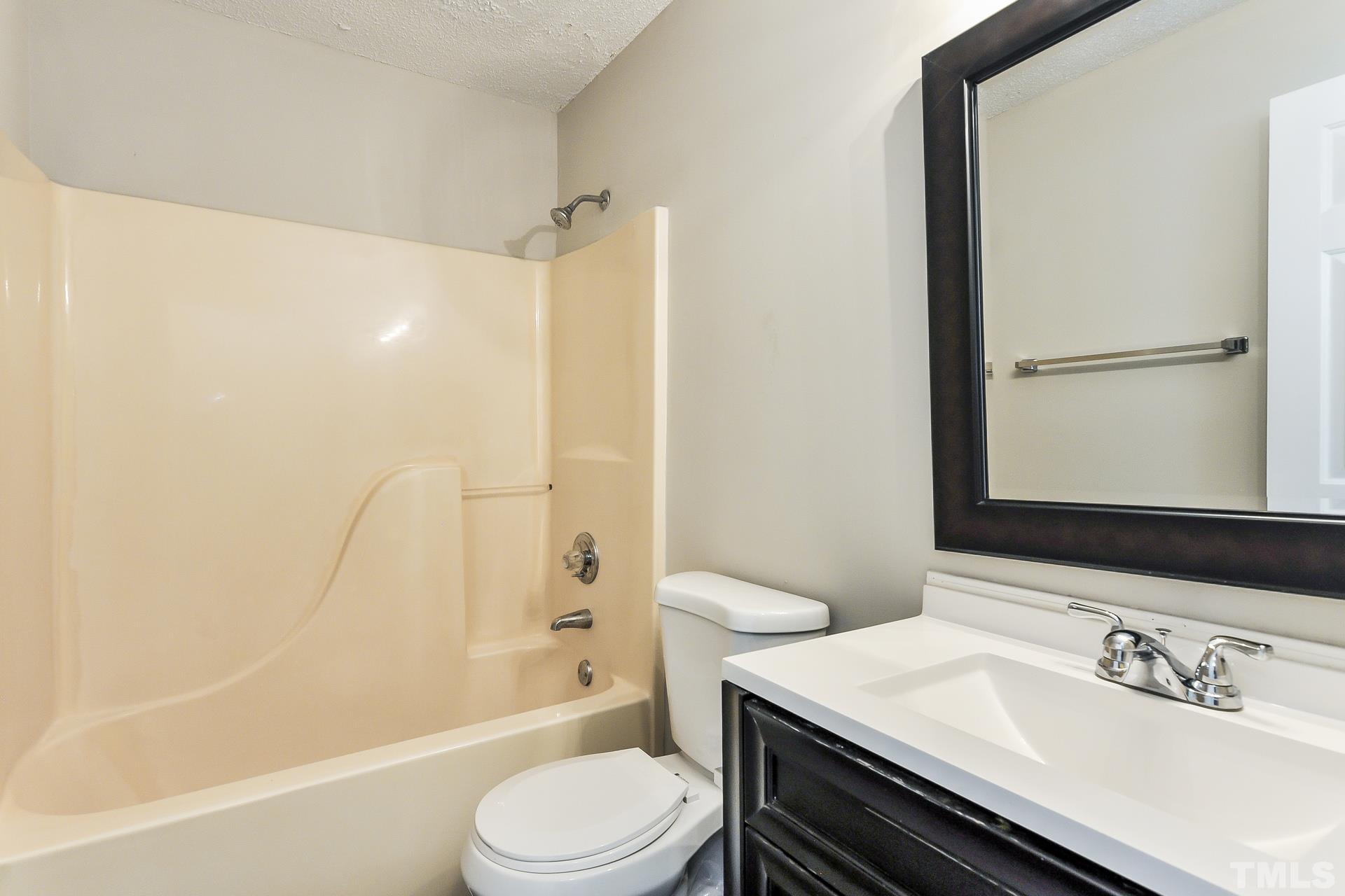 38 Greene Court Angier, NC 27501 - Photo 11 of 16 a bathroom with a sink a toilet and shower