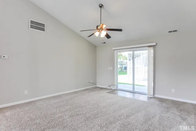 an empty room with fan and windows