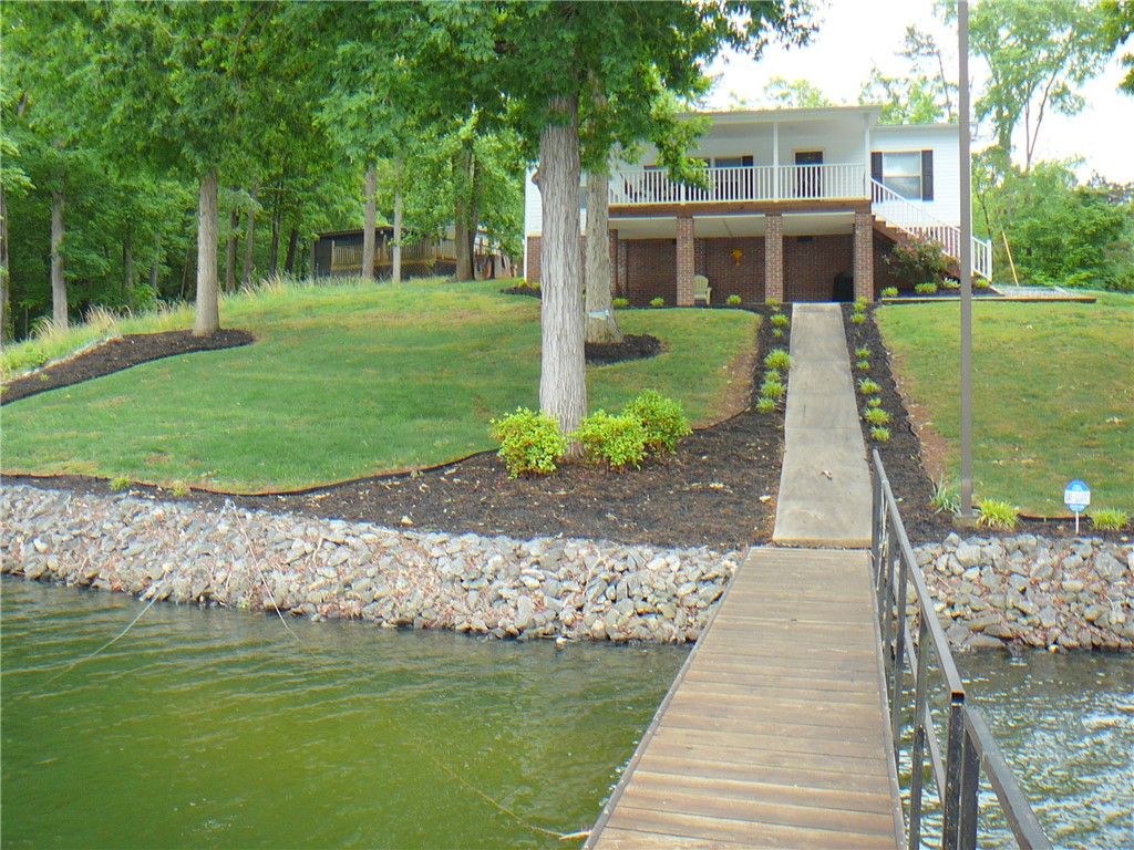 This captivating waterfront property boasts a private dock and lush, well-maintained landscaping.