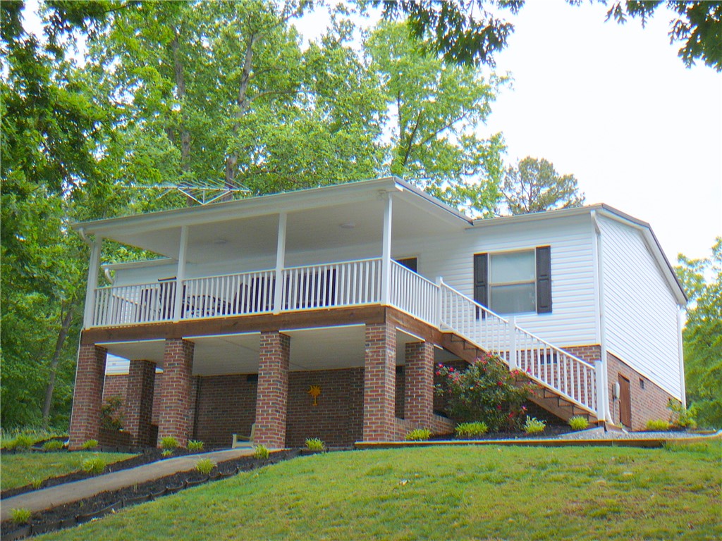34 Owens Point Road Abbeville, SC 29620 - Photo 2 of 22 This elevated home offers a delightful covered porch, ideal for relaxation and enjoying the natural surroundings.