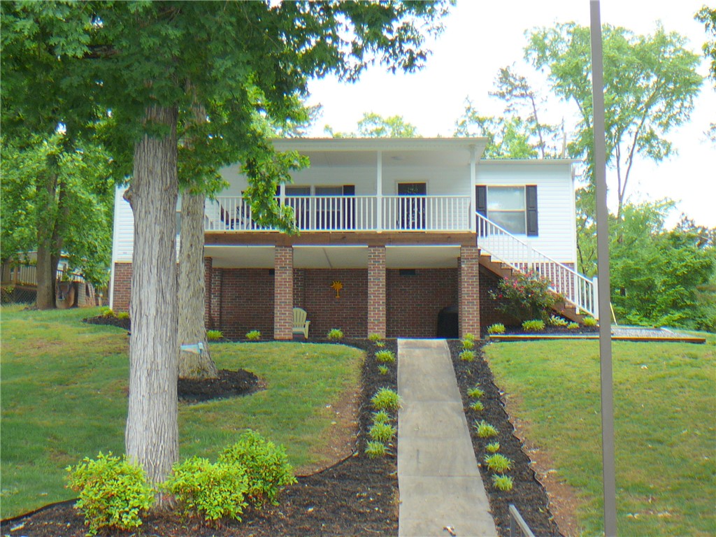 34 Owens Point Road Abbeville, SC 29620 - Photo 5 of 22 This elevated home offers a welcoming facade with a balcony and exterior stairs leading to the entrance.