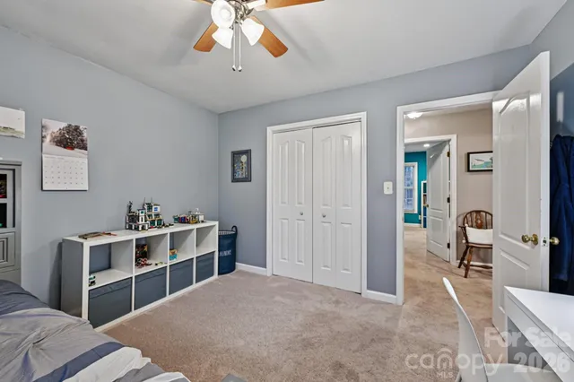 a view of a bedroom with workspace and windows