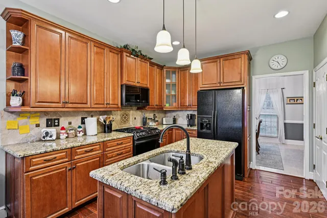 a kitchen with stainless steel appliances granite countertop a sink refrigerator and microwave