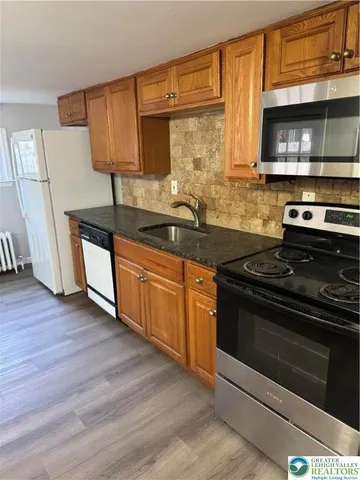a kitchen with stainless steel appliances wooden cabinets and a stove top oven