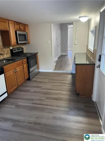 a kitchen with stainless steel appliances wooden floors and wooden cabinets