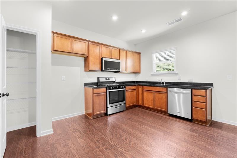 5899 Wheeler Ridge Road Auburn, GA 30011 - Photo 21 of 43 a kitchen with granite countertop a stove top oven and sink
