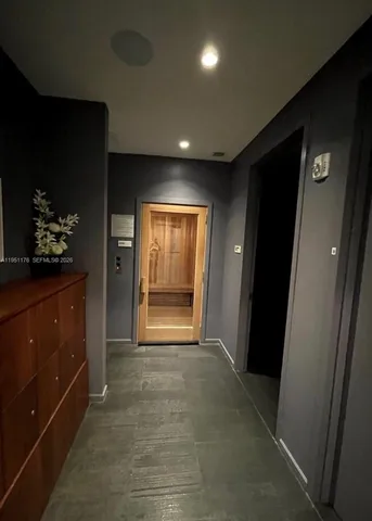 a view of hallway with a door and a dresser