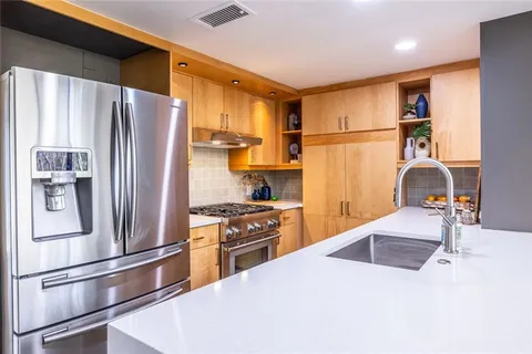 a kitchen with stainless steel appliances a refrigerator stove and sink