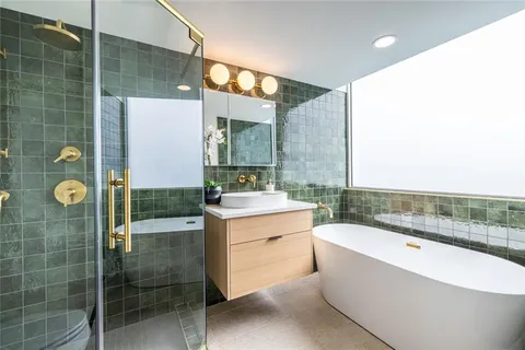 a bathroom with a bathtub a sink and mirror