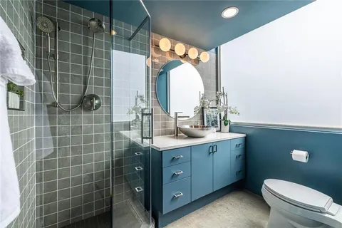 a bathroom with a double vanity sink toilet and a mirror