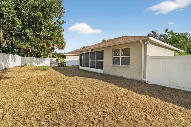 an aerial view of a house with outdoor space and trees all around
